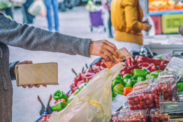Woman,Paying,For,Vegetables,On,The,Street,Market