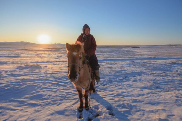 Frau und ihr Pferd grüßen Sie freundlich in der verschneiten Steppe