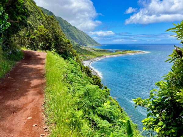 Küstenpfad über einer grünen Bucht auf São Jorge, Azoren